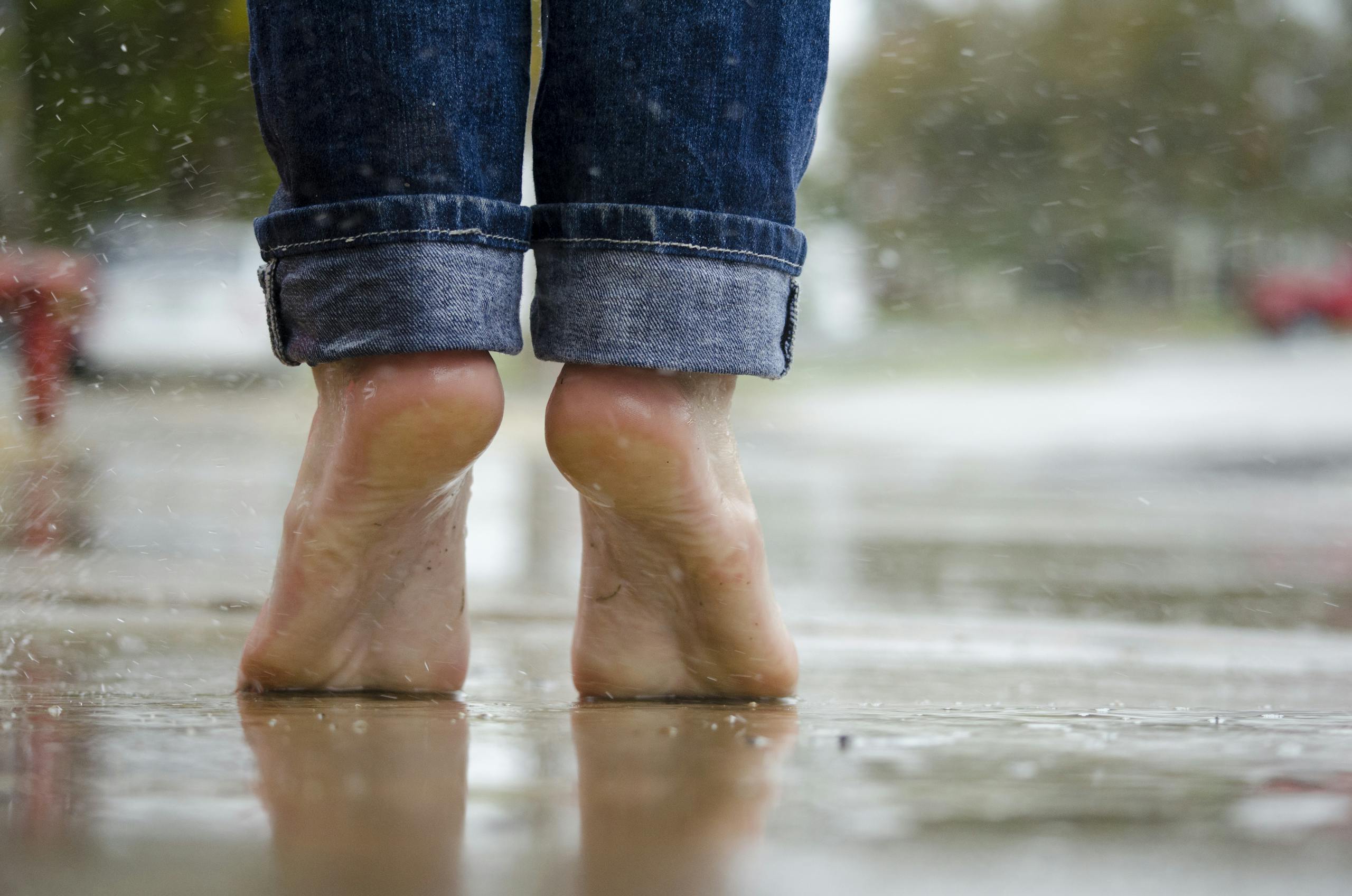 Person in Blue Denim Jeans Standing Outside the Rain